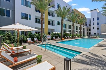 Swimming pool with lounge chairs and a building in the background